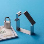 Stack of banknotes with padlock and house-shaped cutout symbolising secure home finance on blue background