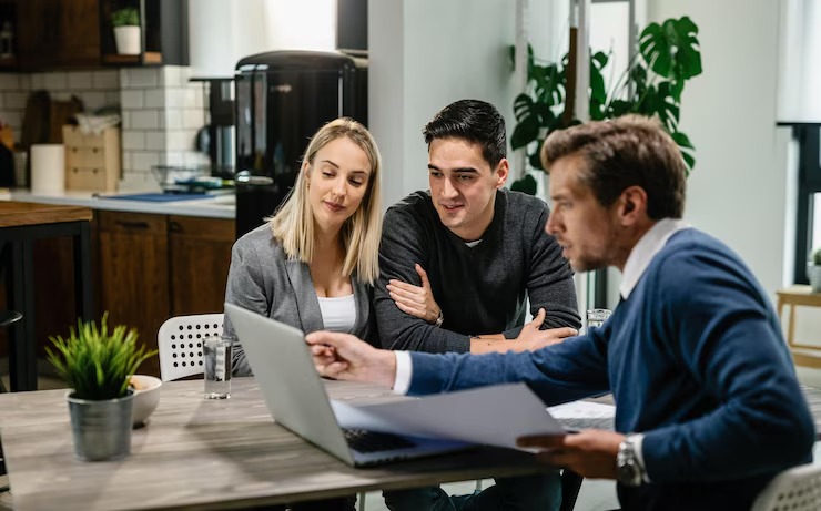 A couple discussing financial planning with a consultant in a modern office setting