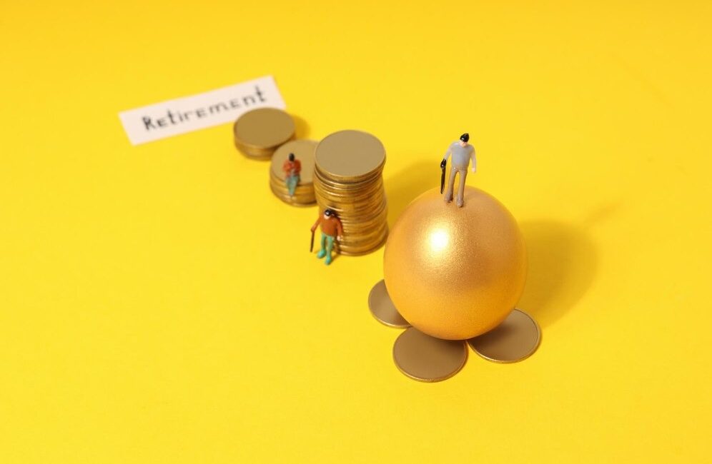 A golden egg surrounded by coins on a bright yellow background, representing the concept of retirement planning
